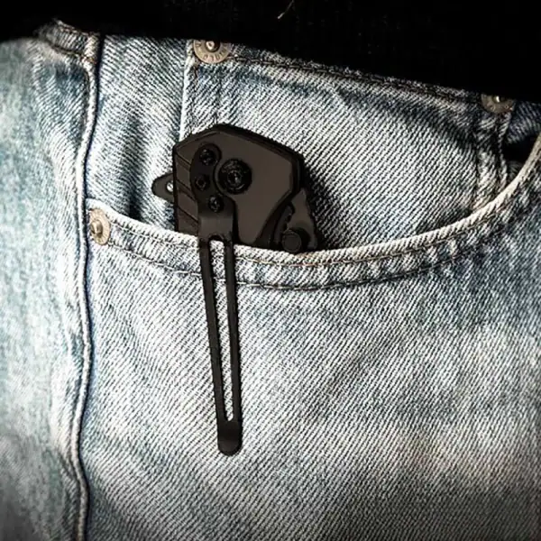 K17 VERGE All-Black tactical folding knife with glass breaker and rope cutter in denim pocket.