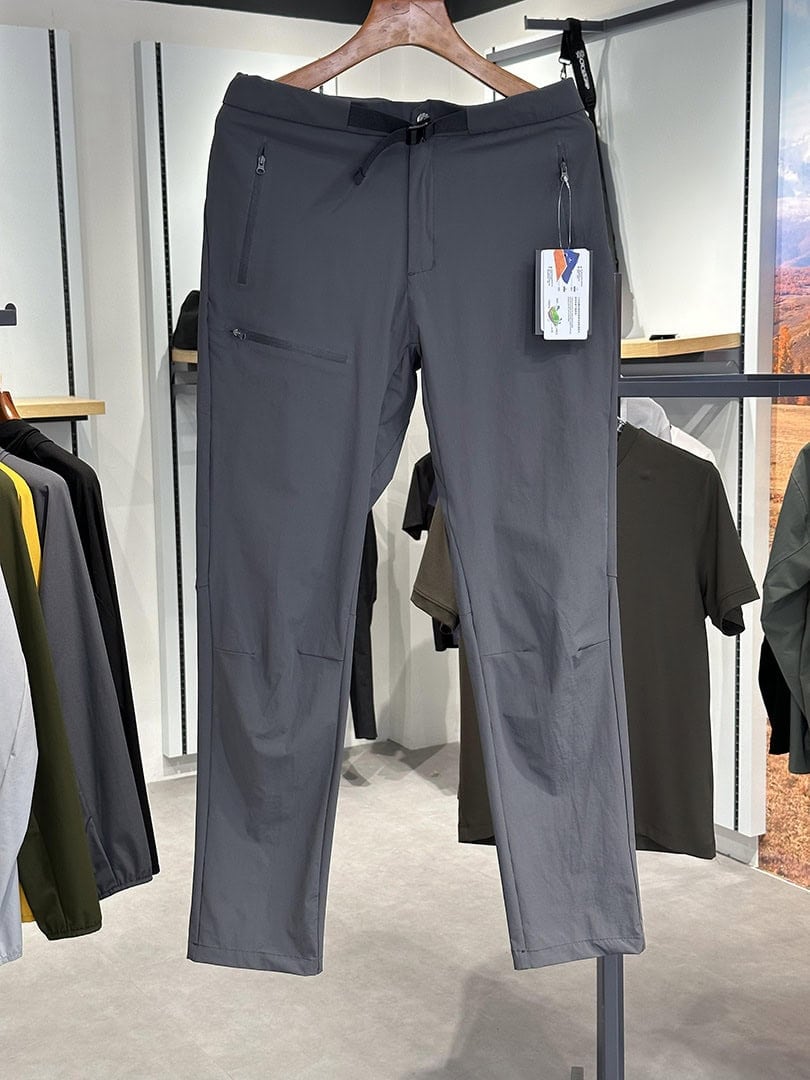Men's lightweight softshell outdoor pants in dark gray with built-in belt and zipper pockets.