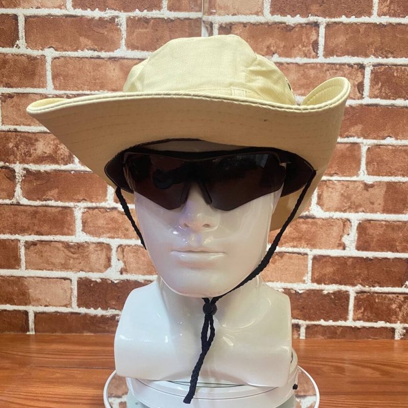Beige wide-brim outdoor hat with black chin strap and sunglasses on mannequin head.