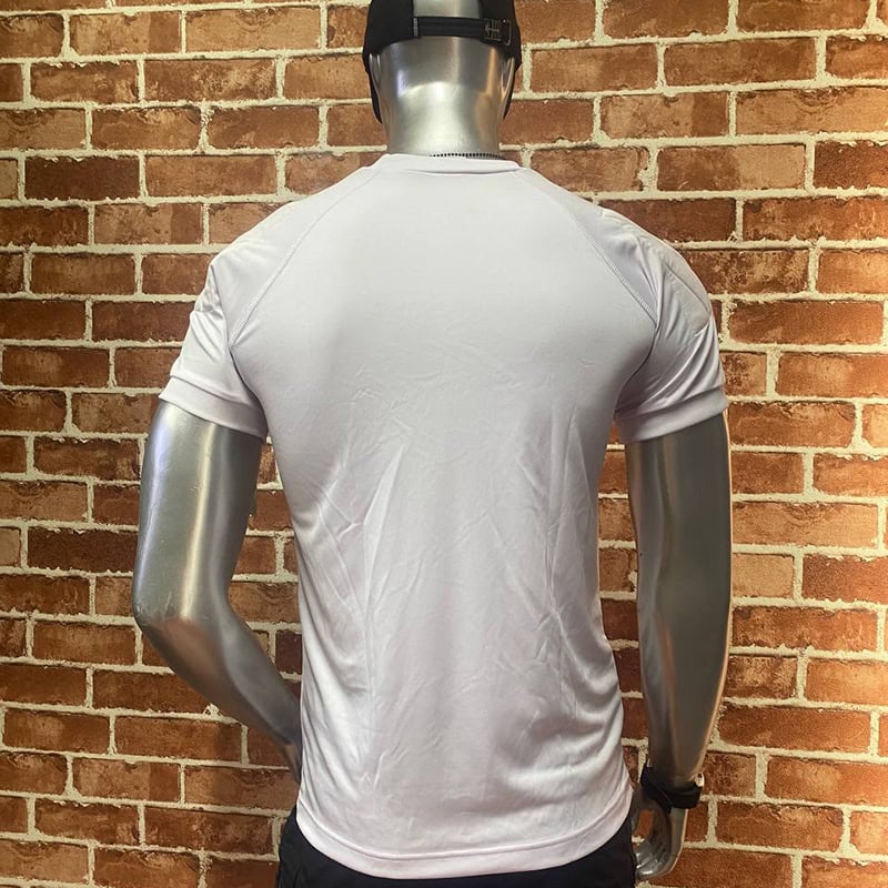 White TSS28 Athletic T-Shirt with raglan seams and circular chest emblem on a mannequin against brick wall.
