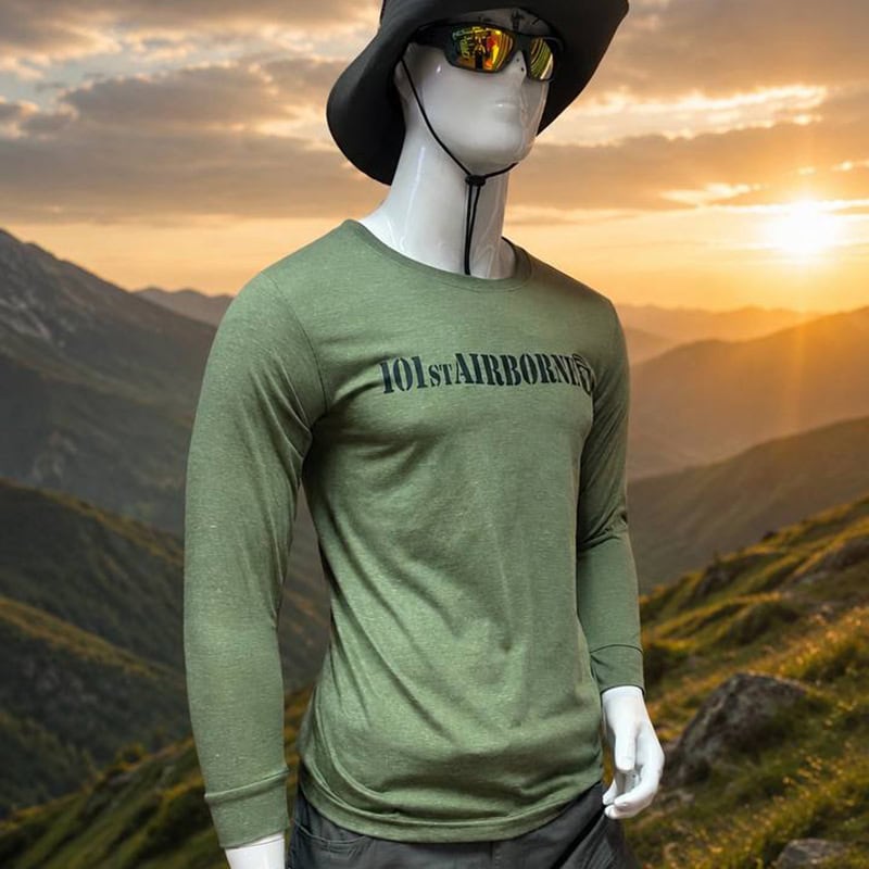 Green tactical long-sleeve shirt with 101st Airborne graphic, outdoor mountain background, tactical style.