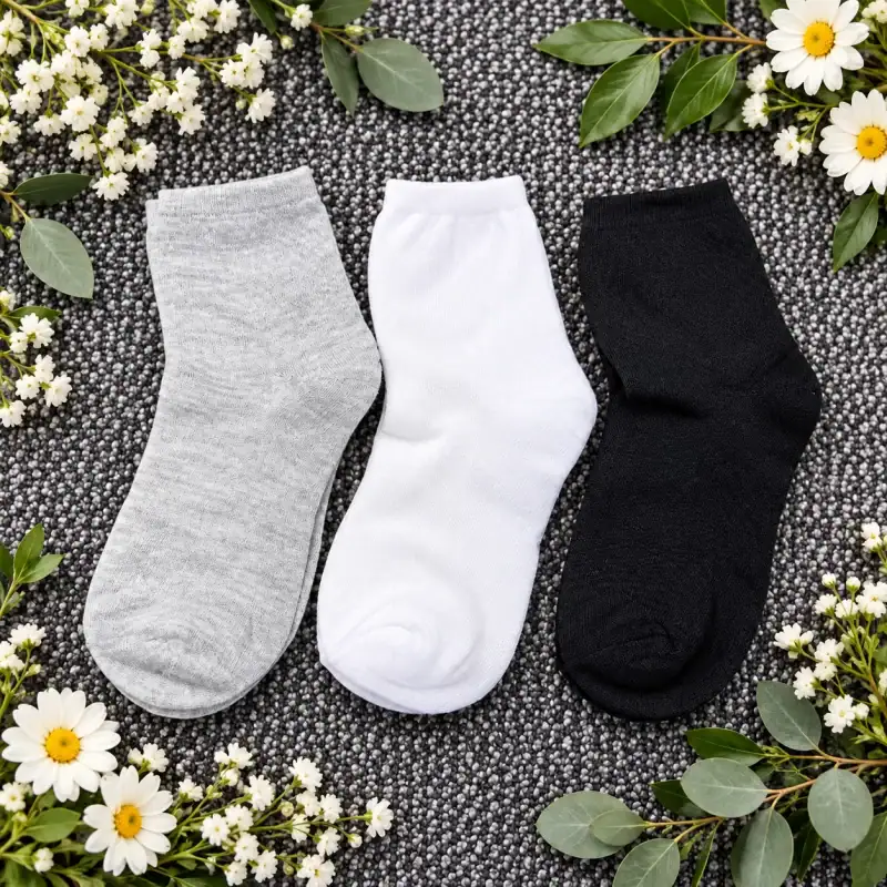 SO05 socks in white, gray, and black colors, casual style, on textured background with flowers.