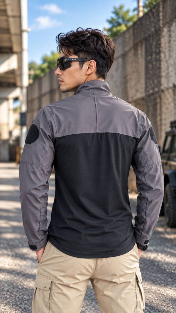 Tactical long-sleeve half-zip shirt with arm patch panels and adjustable cuffs in two-tone gray and black.