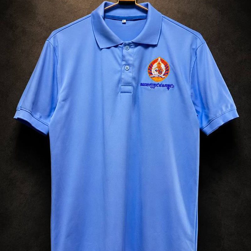 Blue embroidered short-sleeve polo shirt with logo and text on chest.